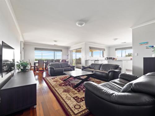 uma sala de estar com sofás e uma mesa em The Dunes Pet Friendly Beachfront Family Retreat Busselton em Busselton