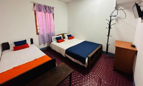 a hotel room with two beds and a window at TPK Trinco Holiday Inn in Trincomalee