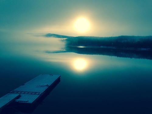 a view of a lake with the sun in the sky at Tärnaby Rooms & Apartments in Tärnaby