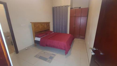 1 dormitorio con 1 cama con manta roja en Heritage Accommodation, en Kigali