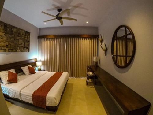 a bedroom with a bed and a ceiling fan at Santai Toraja in Rantepao