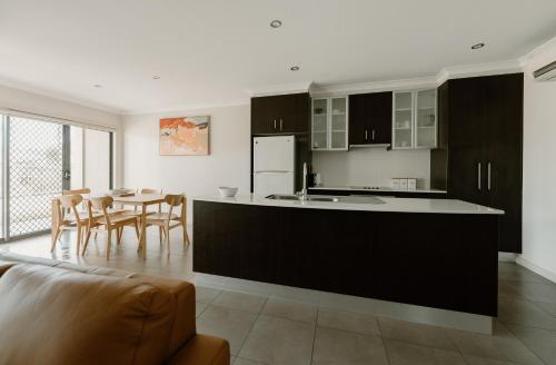 a kitchen and dining room with a table and chairs at Yarrawonga Waterfront Apartments in Mulwala