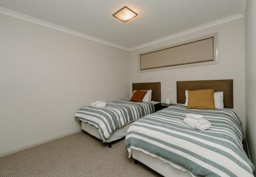 two beds sitting next to each other in a room at Yarrawonga Waterfront Apartments in Mulwala