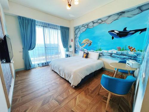 una habitación de hotel con una cama con un mural de delfines en Amibao Resort en Hengchun Old Town