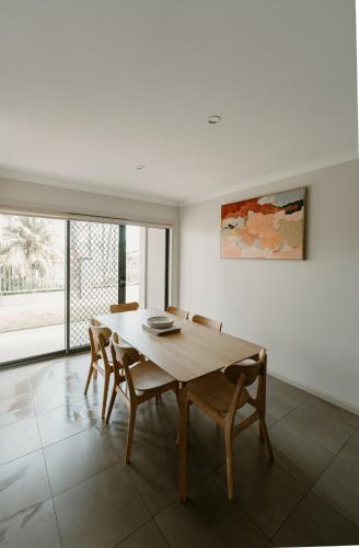 a dining room with a wooden table and chairs at Yarrawonga Waterfront Apartments in Mulwala