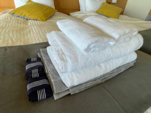 那須 にごり湯の大浴場露天風呂があるホテルコンドミニアム في Nasu-yumoto: سريرين مع مناشف مكدسة فوق بعض