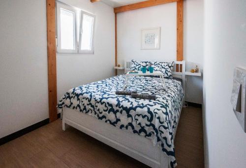 ein Schlafzimmer mit einem Bett mit einer blauen und weißen Decke in der Unterkunft Marina Oceano in La Mareta