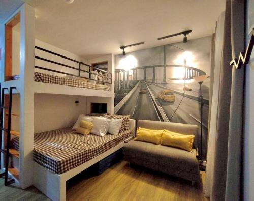 - un salon avec des lits superposés et un canapé dans l'établissement Antara-QueenBed-Balcony-HotShower-WorkCoffee Station-FullKitchen, à Talisay