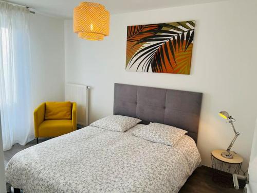 a bedroom with a bed and a yellow chair at Harmonieux/Bezannes/Pkg Privé in Bezannes-les-Reims