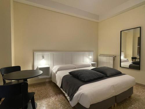 - une chambre avec un lit, une table et un miroir dans l'établissement YOME-GUICCIARDINI 10, à Florence