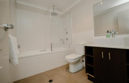 a bathroom with a toilet and a shower and a sink at Yarrawonga Waterfront Apartments in Mulwala