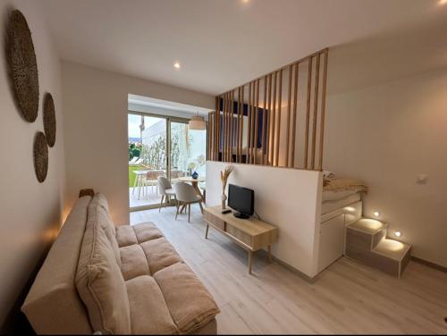uma sala de estar com um sofá e uma secretária com uma televisão em Riviera em Cagnes-sur-Mer