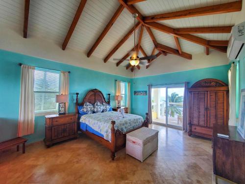1 dormitorio con cama y techo de madera en Lucky Duck Villa - Private Beach Escape, en Maya Beach