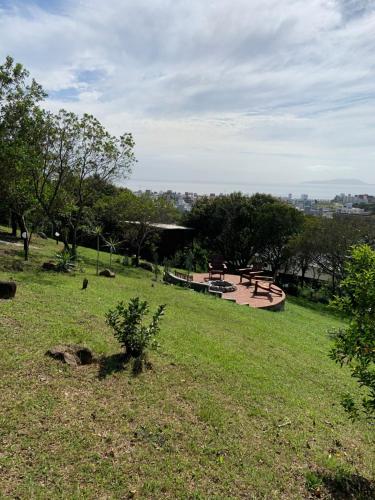 un parque con un banco y mesas de picnic en un campo en Recanto da Vila - Chalé 01, en Governador Celso Ramos