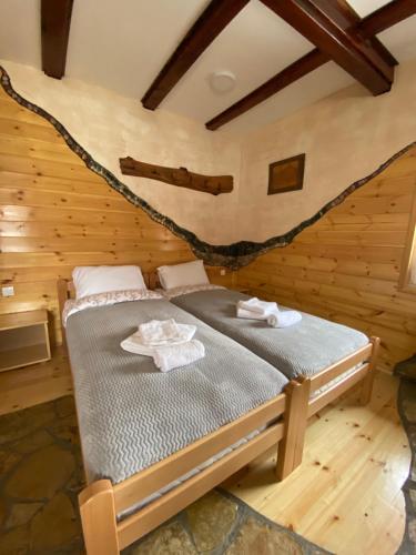 - une chambre avec un lit dans une cabane en rondins dans l'établissement Mini 2 apartmani Nature Connection Drina, à Bajina Bašta