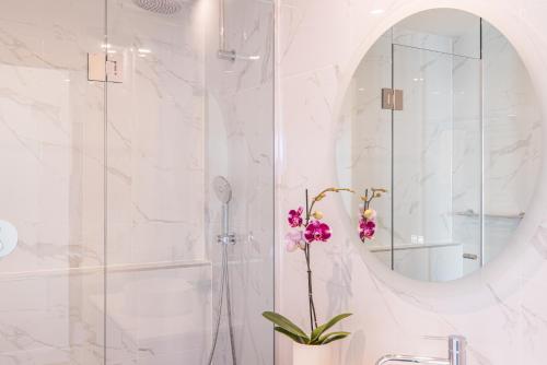 y baño con ducha, lavabo y espejo. en Seasons Botanic Gardens, en Melbourne
