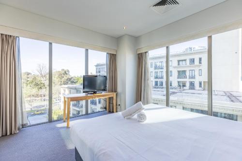 a bedroom with a large bed and a large window at Seasons Botanic Gardens in Melbourne