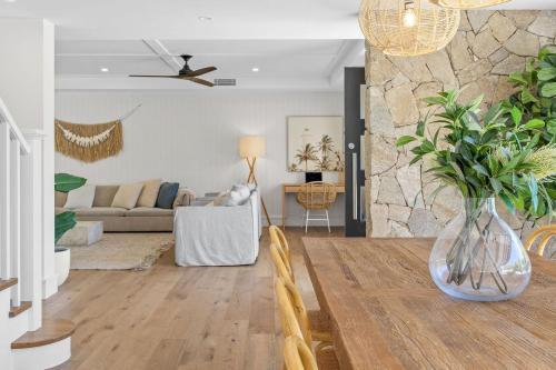 a dining room and living room with a vase on a table at Orana in Byron Bay