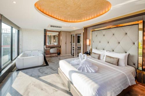 1 dormitorio con 1 cama grande y bañera en The TJ Hotel Jomtien, en Jomtien Beach