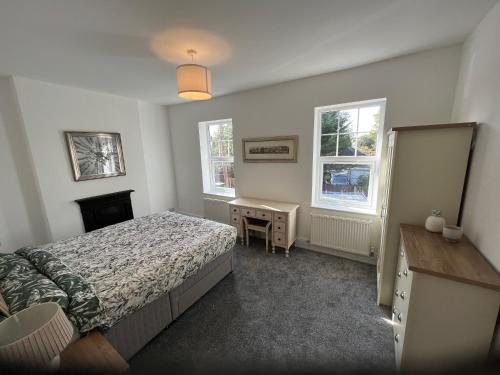 - une chambre avec un lit, un bureau et 2 fenêtres dans l'établissement Formby house, à Formby