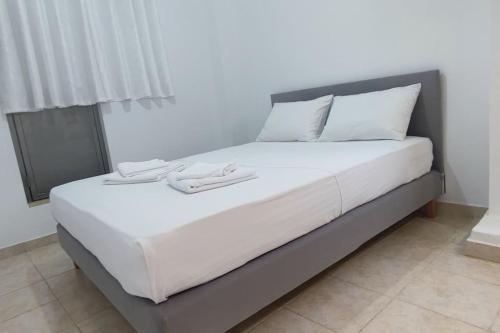 a bed with two white shoes on top of it at Nektar-apartments in Piraeus