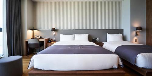 - 2 lits dans une chambre d'hôtel avec un bureau et une sidx dans l'établissement Kumuda Les Maison, à Busan