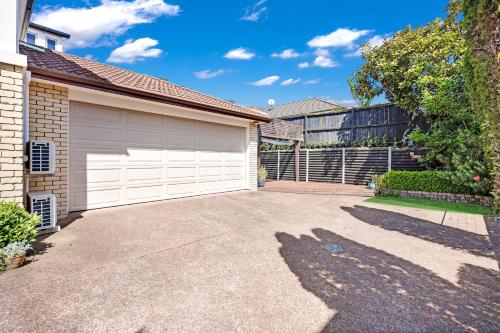 a driveway in front of a house with a garage at The Oasis in Auckland