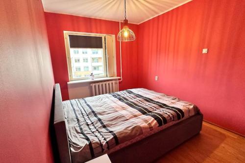 a bedroom with a bed in a red wall at Only 5 min. From Tallinn Airport in Petrikyula