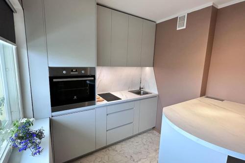 a small kitchen with a stove and a sink at Only 5 min. From Tallinn Airport in Petrikyula