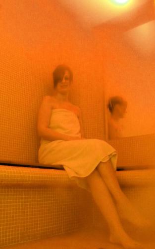 a woman in a white dress sitting in a bathroom at I Tre Merli Locanda in Camogli