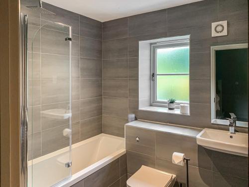 a bathroom with a tub and a toilet and a sink at Nixey Cottage in Turville