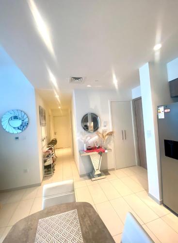 uma sala de estar com paredes brancas e piso em azulejo branco em Luxury cozy private room em Dubai
