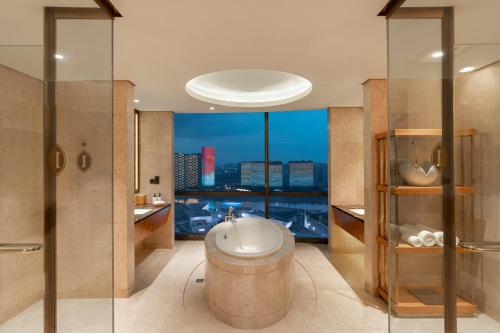 a bathroom with a toilet and a view of the city at InterContinental Changsha, an IHG Hotel in Changsha