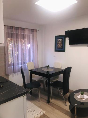 a dining room with a black table and chairs at Apartman J&G in Gornji Milanovac