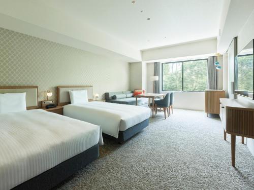 柏市的住宿－Mitsui Garden Hotel Kashiwa-no-ha Park Side - Chiba，酒店客房设有两张床和一张桌子。