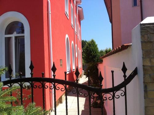 a red and white building with a black fence at Villa Favorita in Eforie Sud