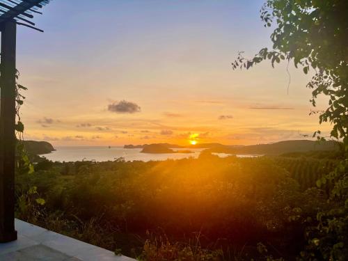 a sunset over a body of water with the sun setting at Lobster Bay Lombok in Awang