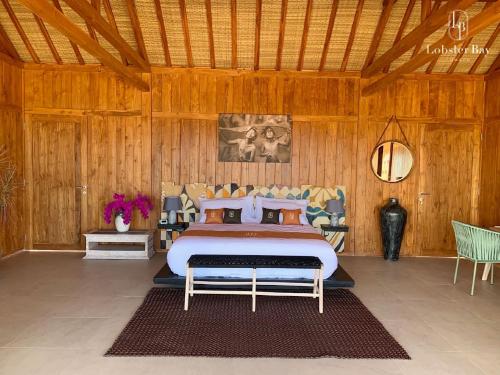 a bedroom with a bed in a wooden room at Lobster Bay Lombok in Awang