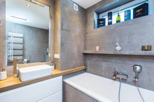 La salle de bains est pourvue d'un lavabo et d'une baignoire. dans l'établissement Krakow Villa Heaven, 