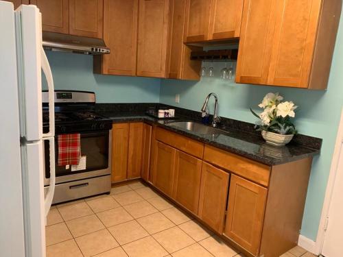 cocina con armarios de madera, fregadero y nevera en Tehama Home - Cozy & Affordable Private Rooms near Berkeley, en Richmond
