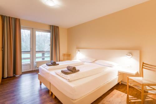 1 dormitorio con 1 cama blanca grande y escritorio en BSW Ferienwohungen Wyk auf Föhr en Wyk auf Föhr