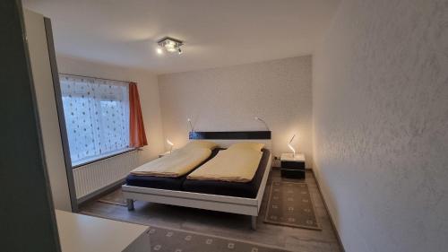 a small bedroom with a bed and a window at Diekkieker - 26909 in Dahme