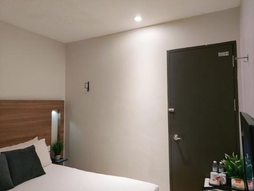 a bedroom with a bed and a black door at The Leverage Business Hotel - Bandar Baru Mergong in Alor Setar