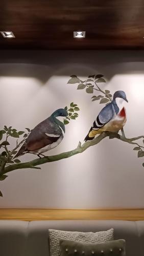 two birds on a tree branch mural on a wall at The Henry Hotel Roost Bacolod in Bacolod