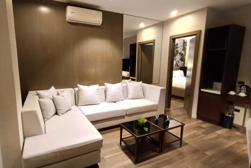 a living room with a white couch and a mirror at The Henry Hotel Roost Bacolod in Bacolod