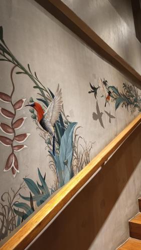 a painting of birds and plants on a wall at The Henry Hotel Roost Bacolod in Bacolod