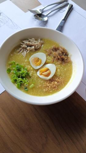 a bowl of soup with three eggs in it at The Henry Hotel Roost Bacolod in Bacolod