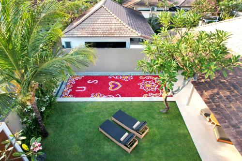 an aerial view of a garden with chairs and a rug at Uma Sapna Seminyak in Seminyak