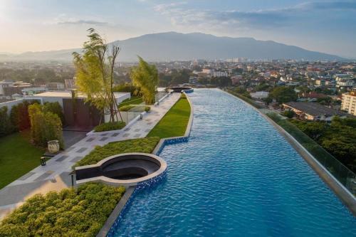 a large pool of water with a city in the background at Luxury Astra Sky River in Chiang Mai