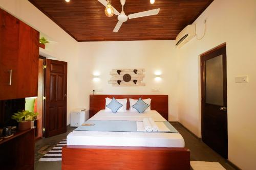 a bedroom with a bed and a ceiling fan at Cozy Villa in Hikkaduwa